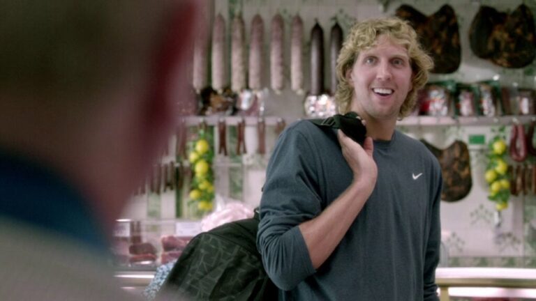 Dirk Nowitzki standing inside a butcher shop, smiling casually.