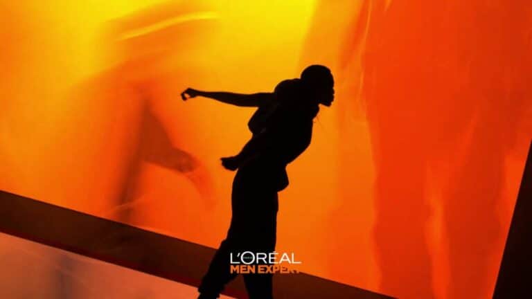 Silhouette of a man balancing dynamically against an orange-lit background.