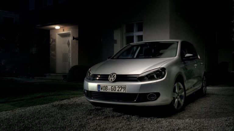 Silver Volkswagen Golf parked outside a house at night